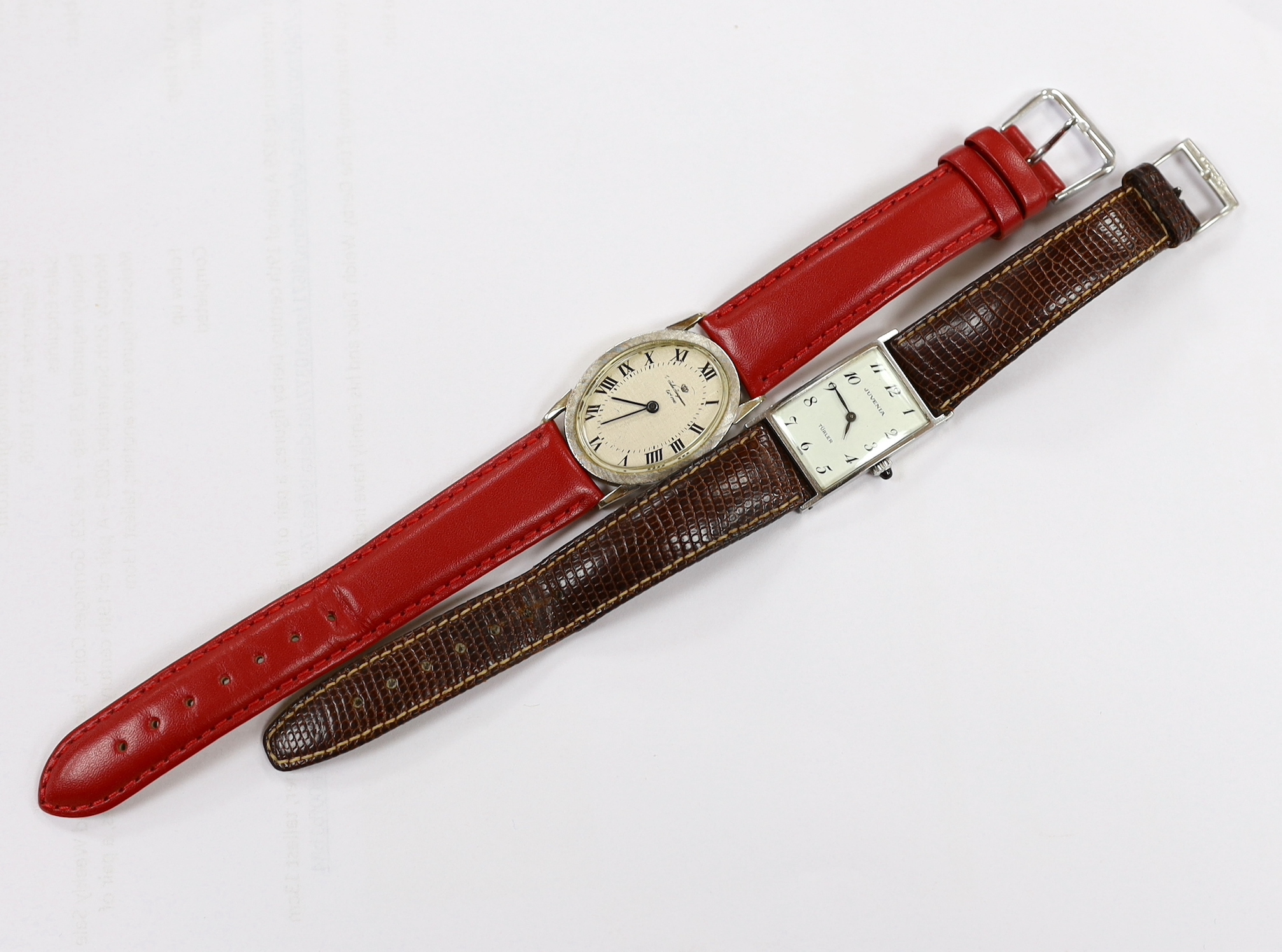 A 14k white metal Jules Jurgensen oval manual wind dress wrist watch, on an associated red leather strap, together with a lady's steel Juvenia manual wind wrist watch.